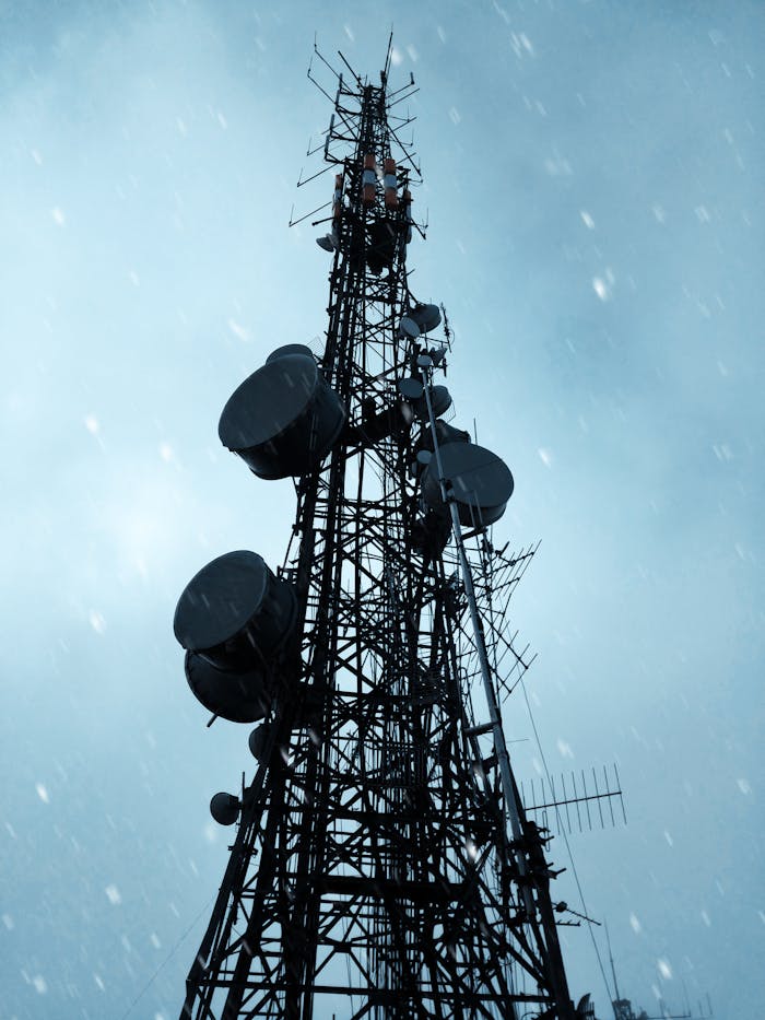 pexels-photo-2415405 Low angle view of a telecommunication tower silhouetted against a dramatic, cloudy sky.